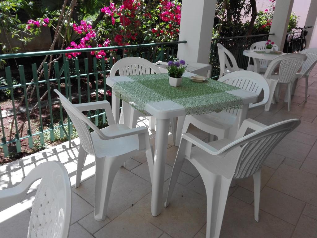a white table and chairs on a patio with flowers at B & B La Magnolia in Specchiolla