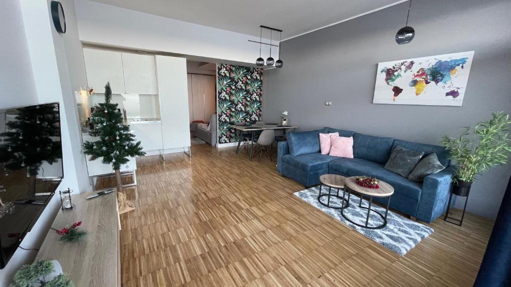 un soggiorno con un divano blu e un albero di Natale di Apartament na Klifie "LUNA" a Ustronie Morskie