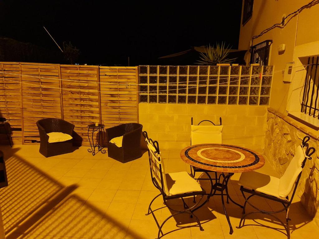 a patio with a table and chairs at night at Casa Sofía in Murcia