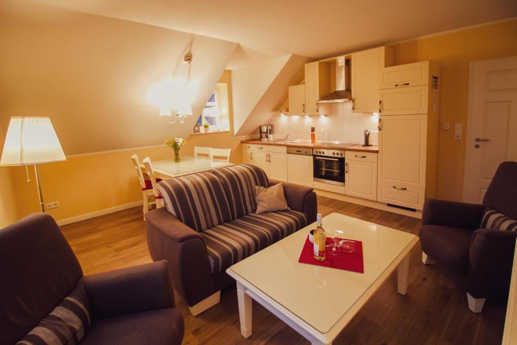 uma sala de estar com sofás e uma mesa e uma cozinha em Int Hörn 8 OG em Krummhörn