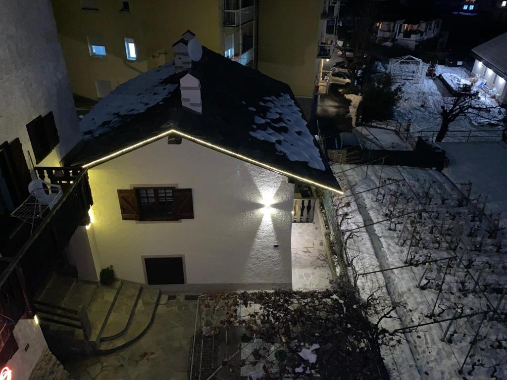 een huis met sneeuw op het dak 's nachts bij Ancienne Maisonnette in Aosta