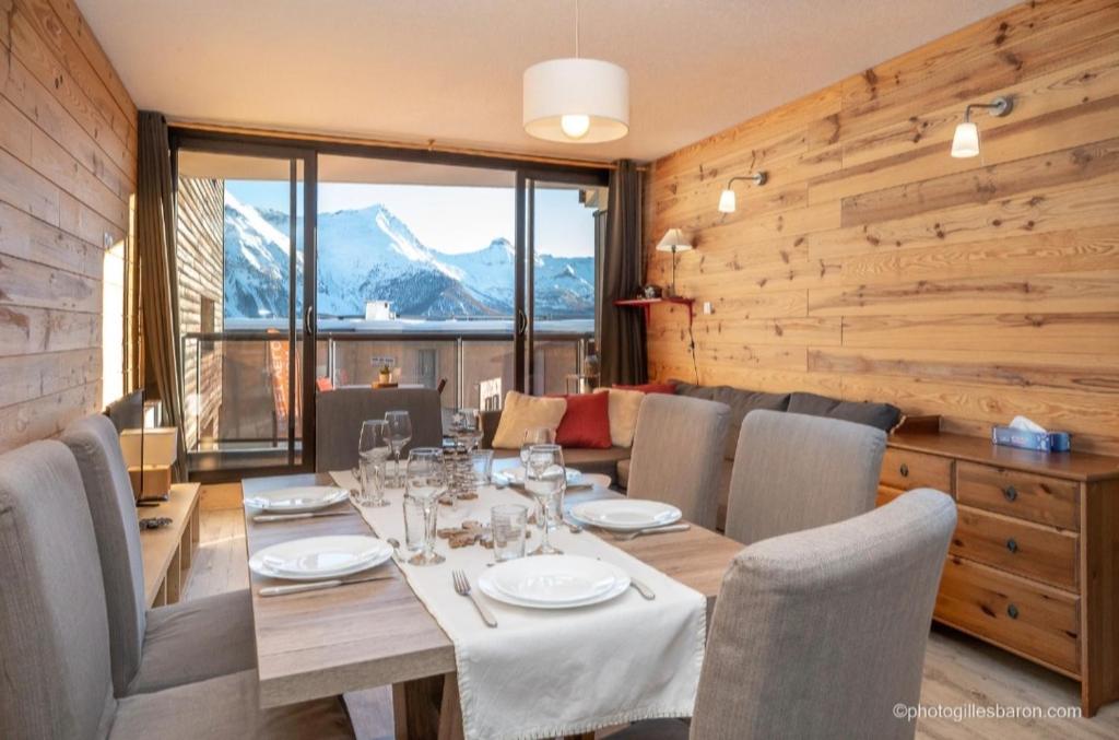 a dining room with a table and chairs and a mountain at Appartement Queyrelet Orcières in Orcières