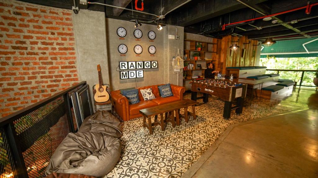 a living room filled with furniture and a clock at Rango Hostel Boutique in Medellín