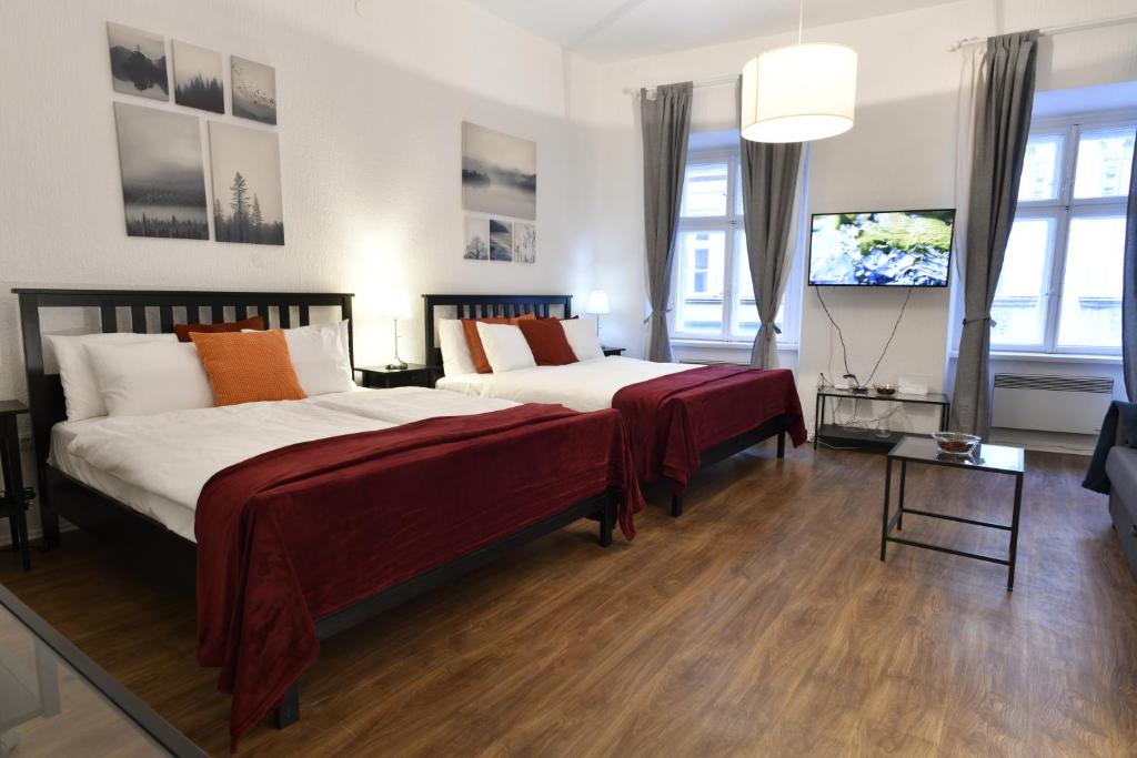 a bedroom with two beds and a flat screen tv at Apartment Callisto in Zagreb