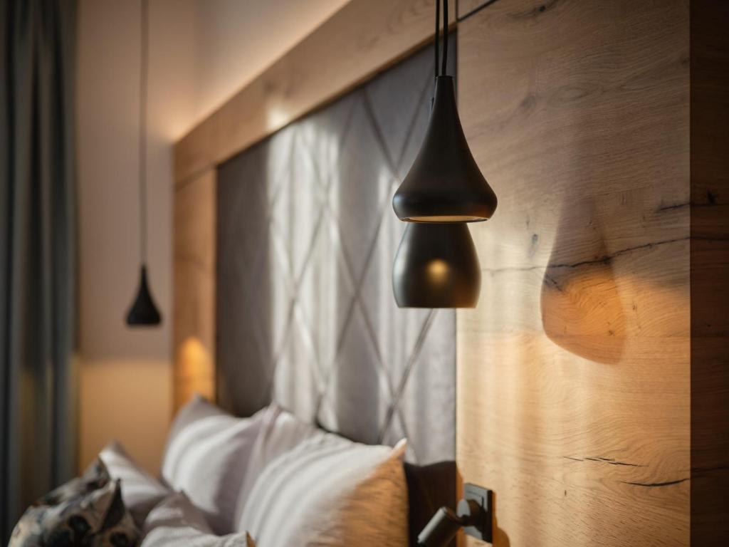 Cette chambre comprend un lit avec une tête de lit en bois. dans l'établissement Sun Lodge, à Ischgl