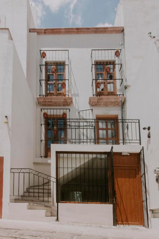 a white building with two balconies and a door at Matiana Estudiante in Zacatecas