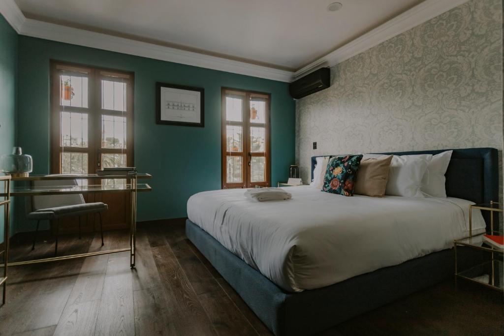 a bedroom with a large bed and green walls at Matiana Estudiante in Zacatecas