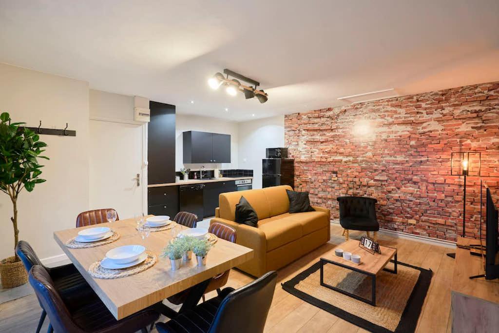 een woonkamer met een bank en een eettafel bij LocationsTourcoing - Le Corneille in Tourcoing