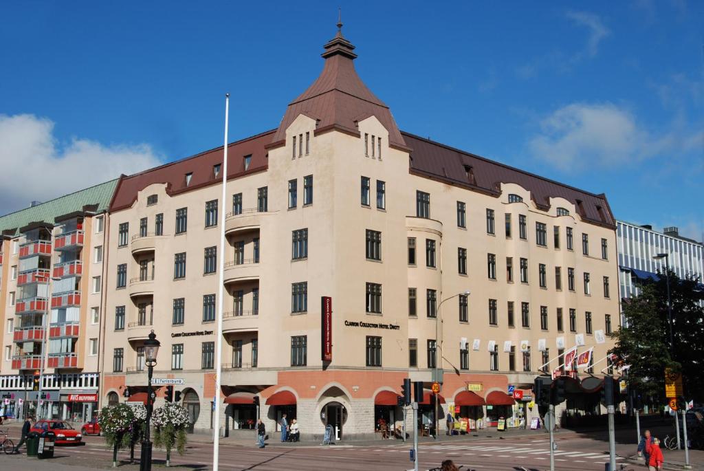 un grand bâtiment blanc avec un toit marron dans l'établissement Clarion Collection Hotel Drott, à Karlstad