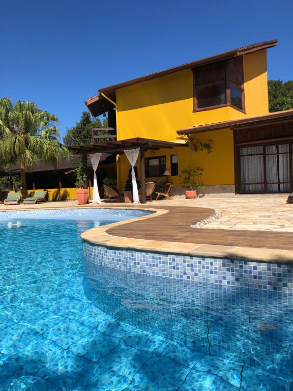 uma casa com piscina em frente a uma casa em Jardim Boêmio em Cananeia