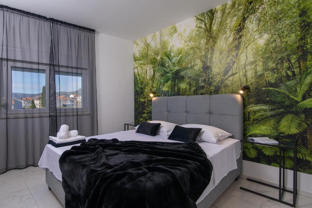 a bedroom with a large bed with a large painting on the wall at Batinic Apartments in Kaštela