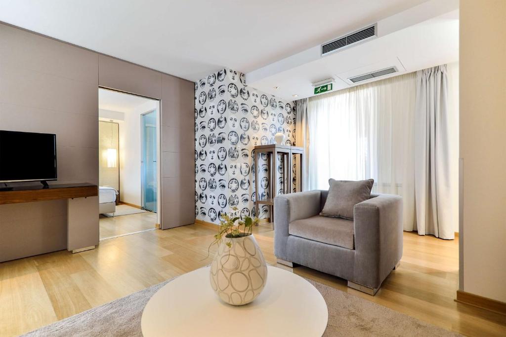 un soggiorno con una sedia e un vaso sul tavolo di Belgrade Art Hotel, a member of Radisson Individuals a Belgrado