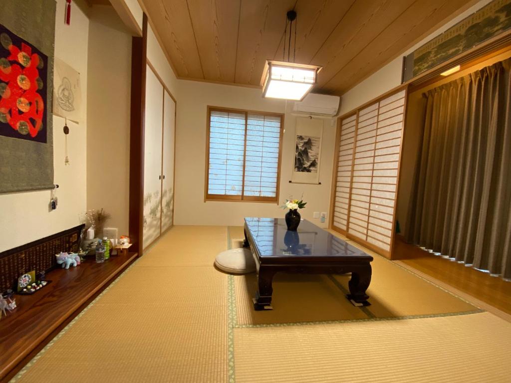 salon ze stołem i oknem w obiekcie 花沢民宿 w mieście Odawara