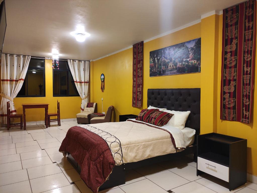 Casa Sucre Ayacucho في اياكوتشو: غرفة نوم بسرير وجدار اصفر