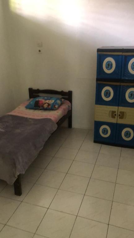 1 dormitorio con 1 cama y vestidor azul en Penginapan al fatih, en Kampungdurian