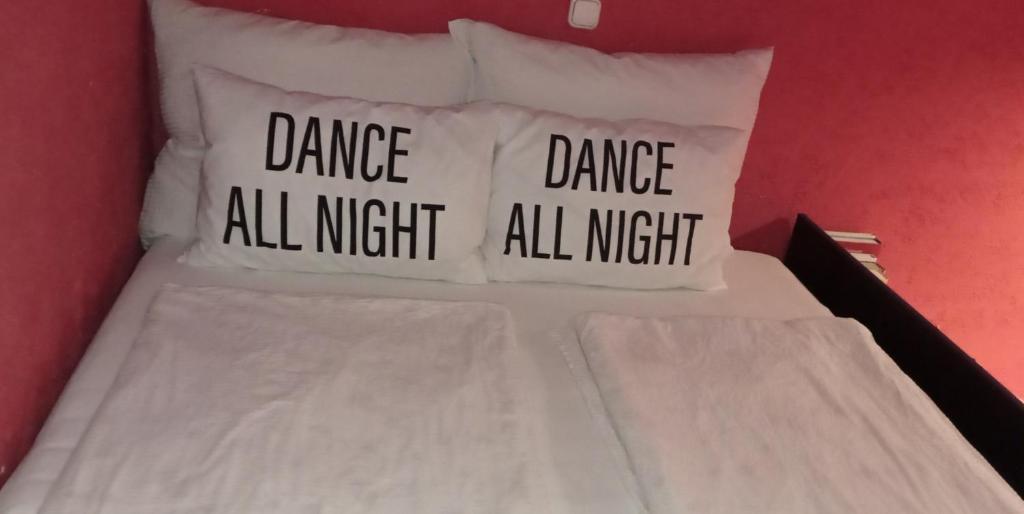 a bed with three pillows with dance dance all night at Studio Gizella in Budapest