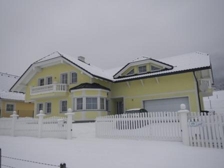 a model of a yellow house with a white fence at Ferienwohnung Schmid in Sankt Martin am Grimming