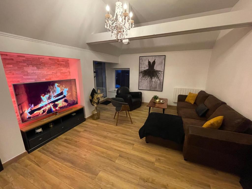 een woonkamer met een bank en een flatscreen-tv bij Love Viou in Ramonchamp