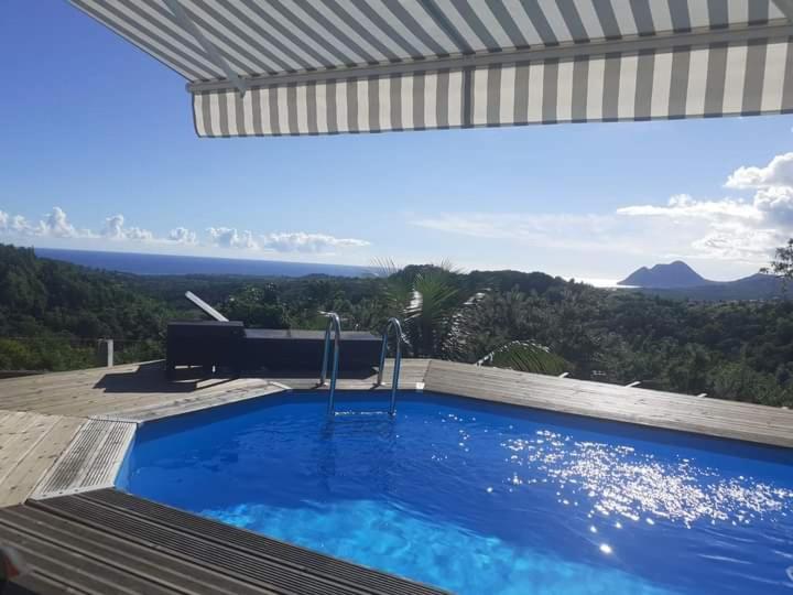 a large swimming pool with a view of the ocean at Chambre chez l'habitant avec piscine privative et vue panoramique sur la mer des caraïbes in Desmarinières