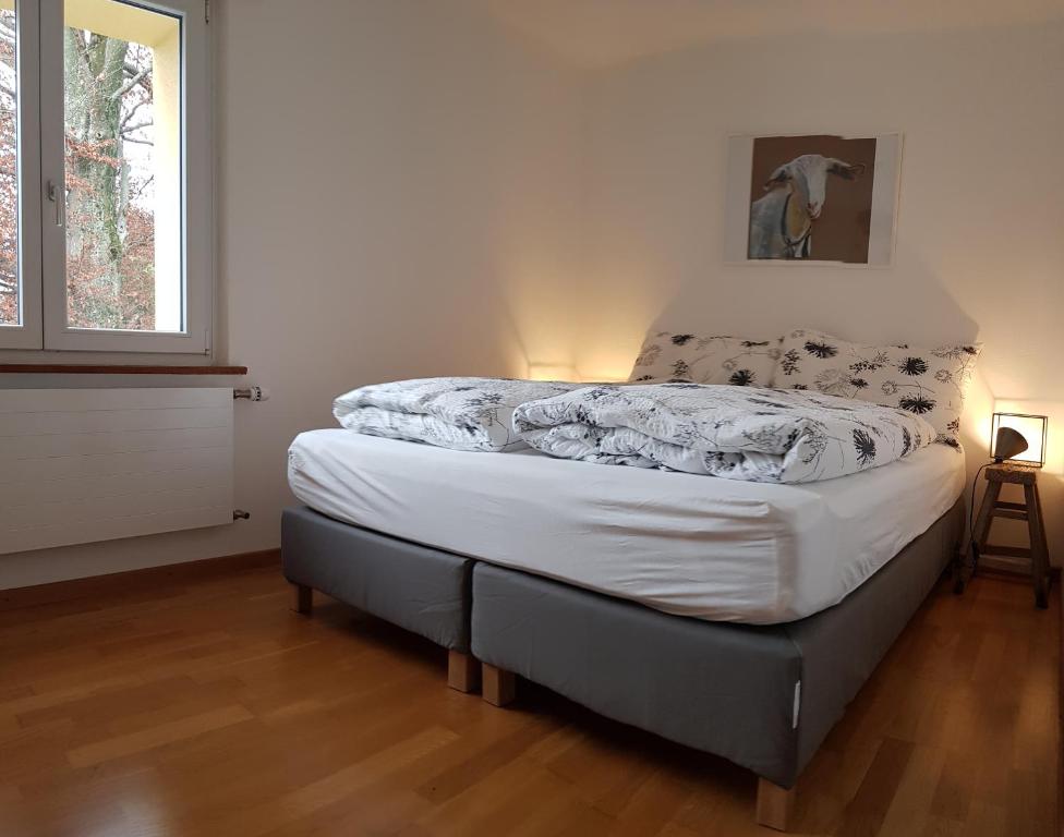um quarto com uma cama com lençóis brancos e uma janela em Interlaken City Apartments em Interlaken