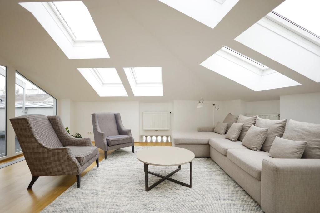 a living room with a couch and chairs and skylights at HeyMi Apartments Oper in Vienna
