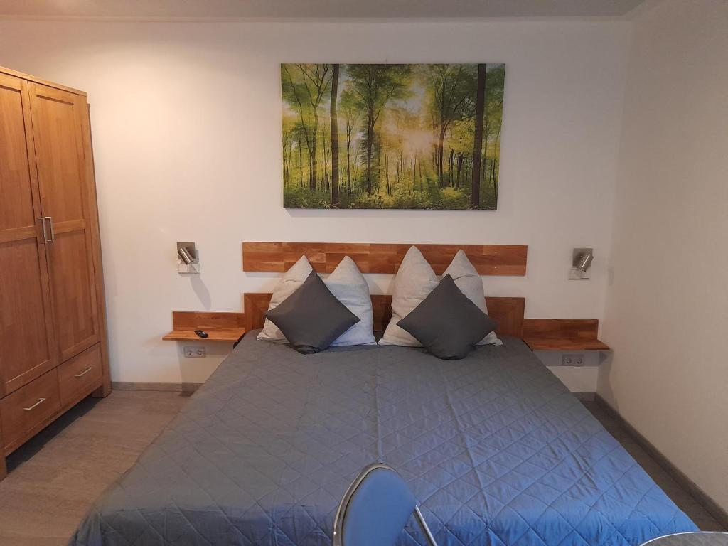 a bedroom with a blue bed with a painting on the wall at Kleines Nest in Radebeul