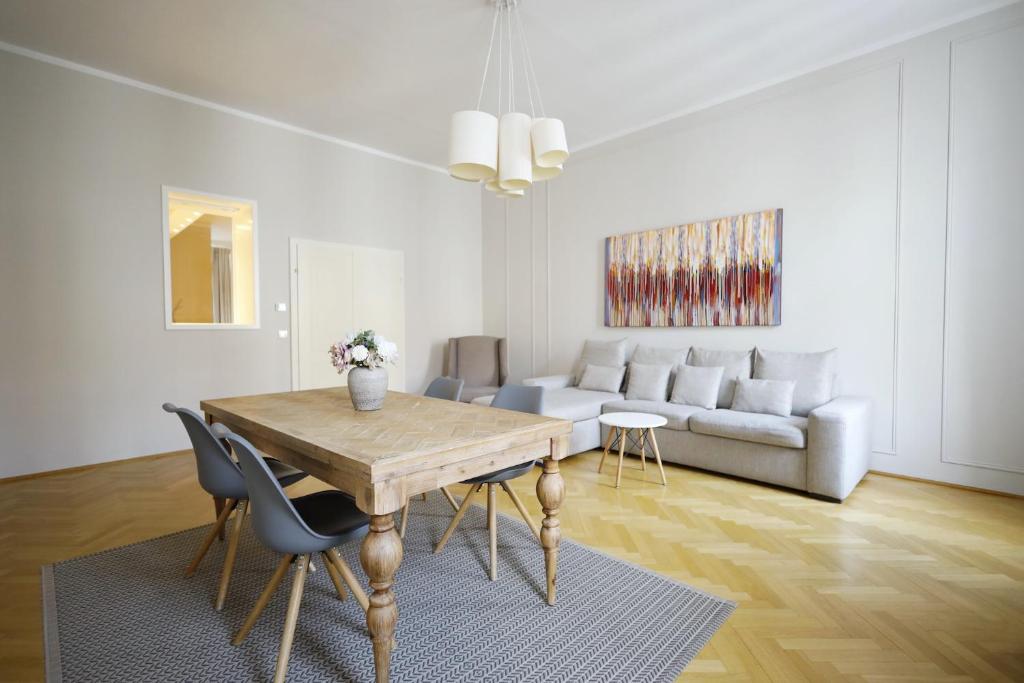a living room with a table and a couch at HeyMi Apartments Karlsplatz in Vienna