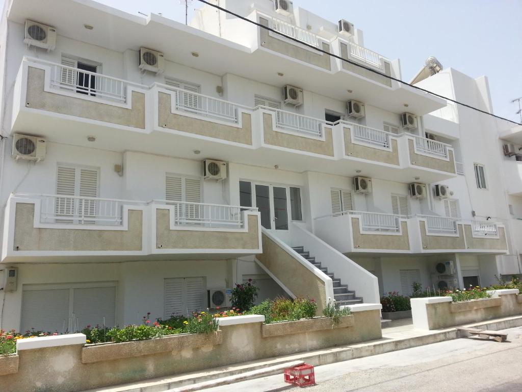 een appartementencomplex met witte balkons en bloemen bij Fania Apartments in Kardamaina