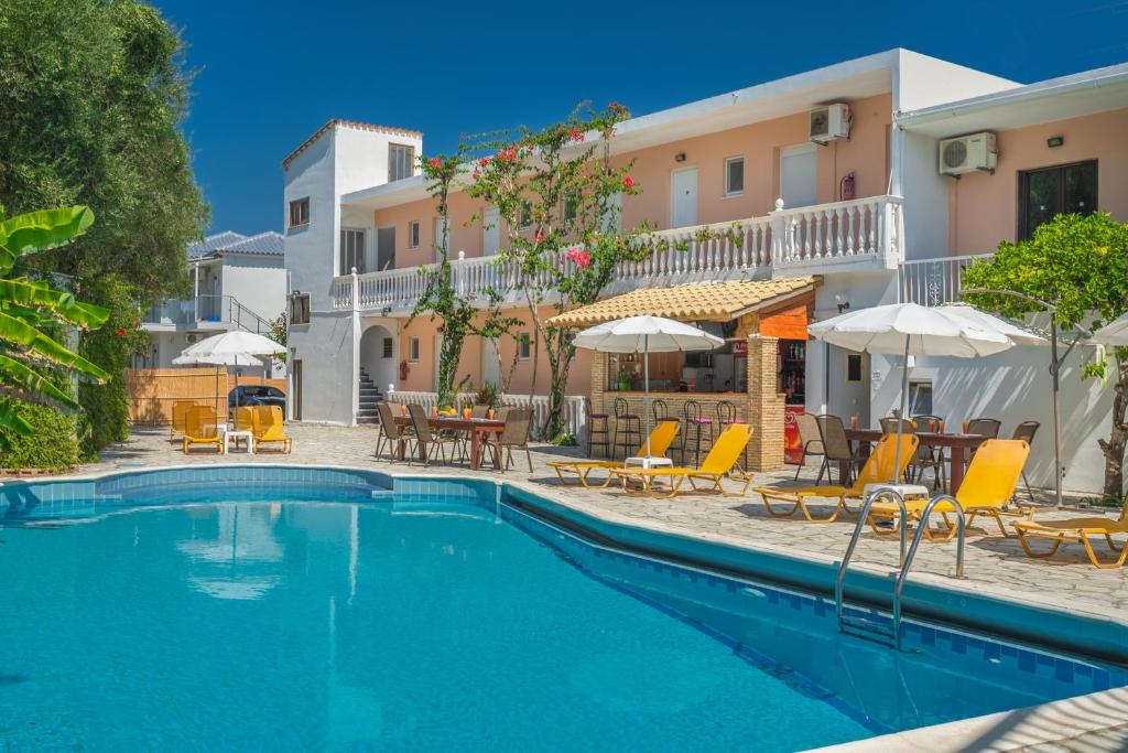 a swimming pool with chairs and tables and umbrellas at Panorama in Laganas