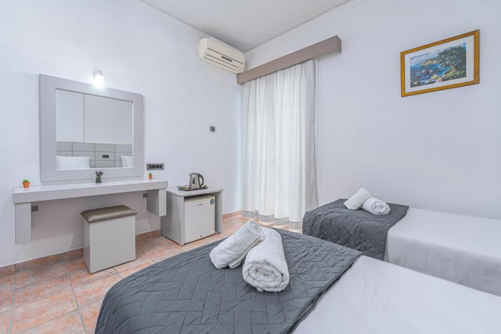 a hotel room with two beds and a desk at Panorama in Laganas