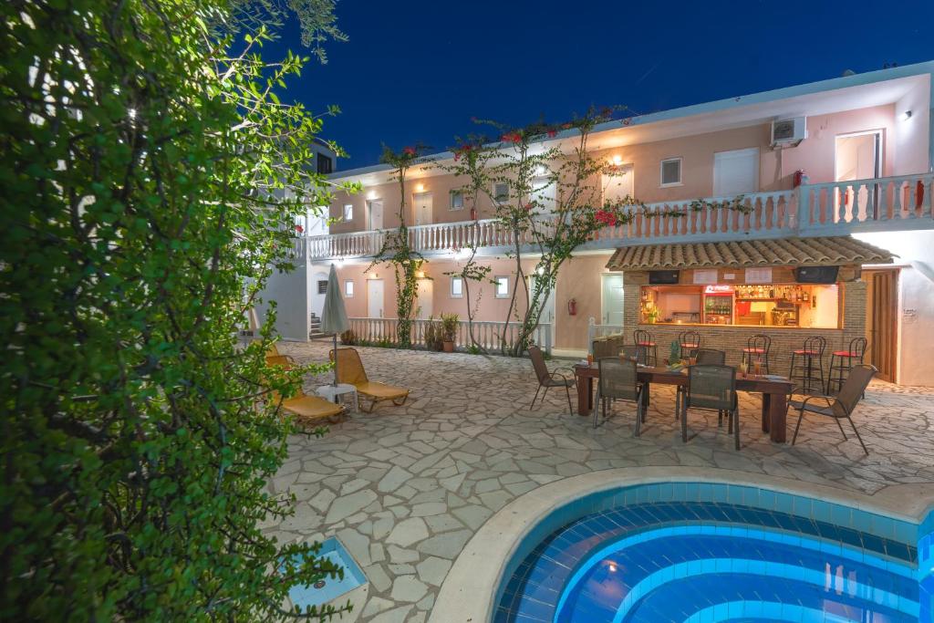 a hotel with a table and chairs next to a pool at Panorama in Laganas
