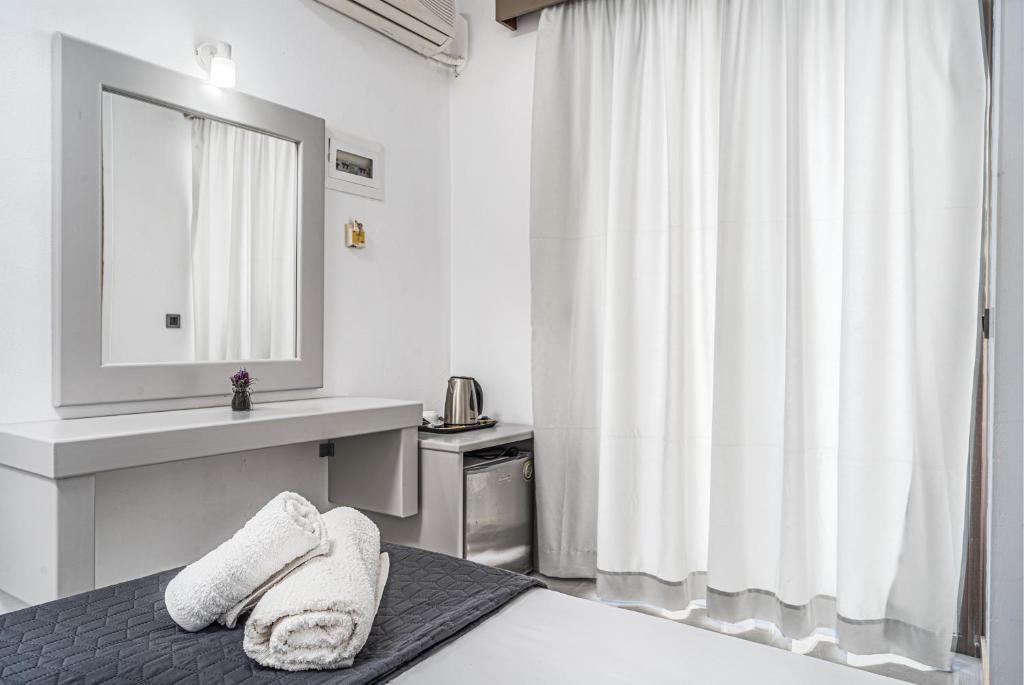 a bedroom with a bed with a sink and a mirror at Panorama in Laganas