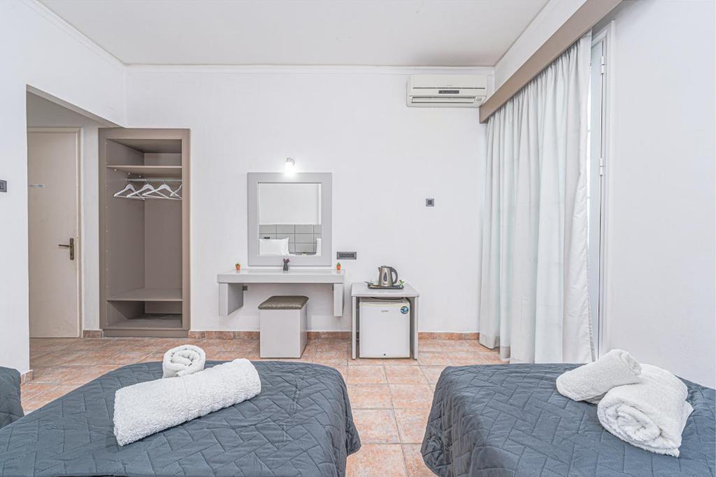 a hotel room with two beds and a sink at Panorama in Laganas