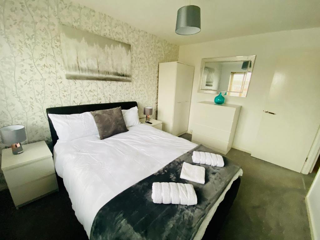 a bedroom with a large bed with three pillows on it at Appian Way in Derby