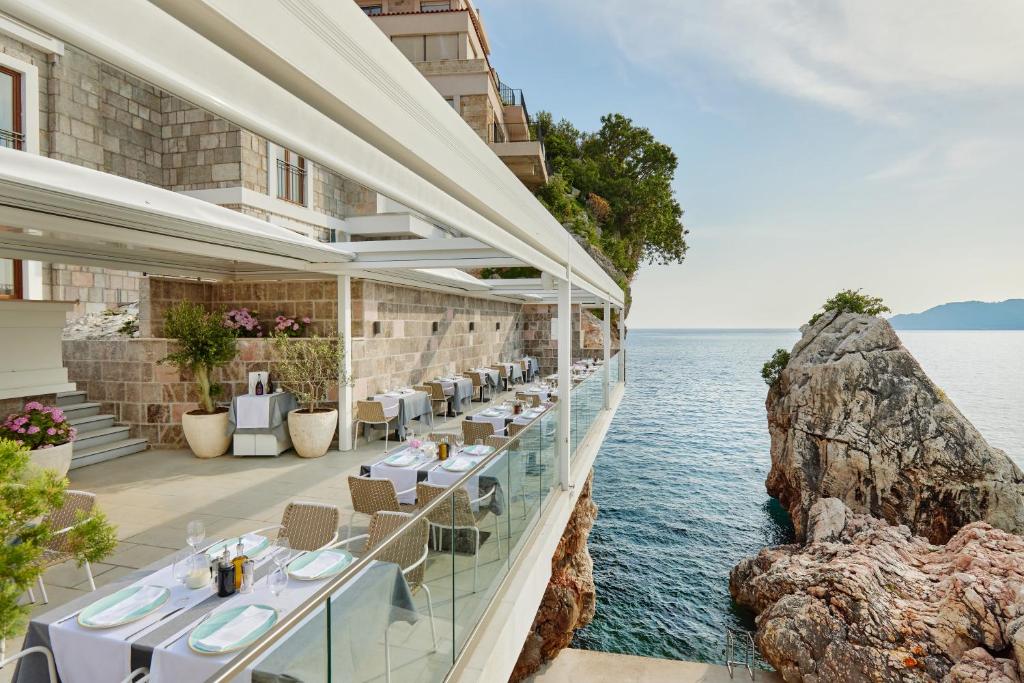 a restaurant with a view of the water at Blanche Cliff Apartments in Sveti Stefan