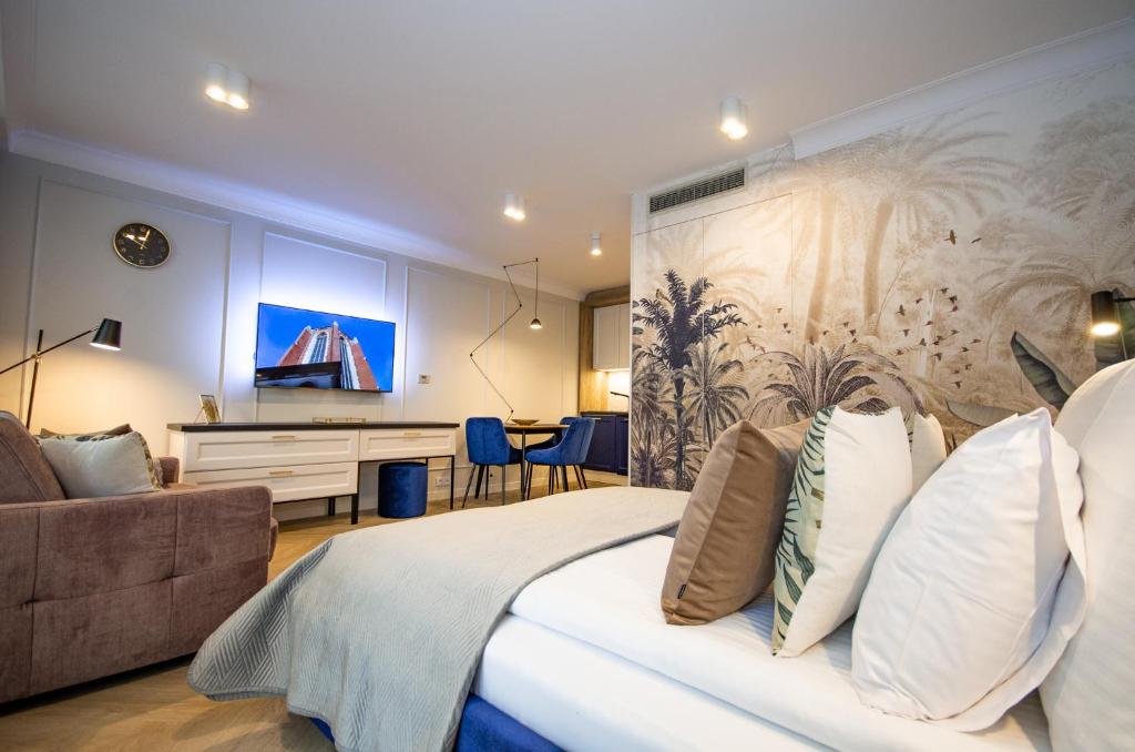 克拉科夫InPoint Central Apartments的一间卧室，里面有一张床、一张沙发和一张桌子