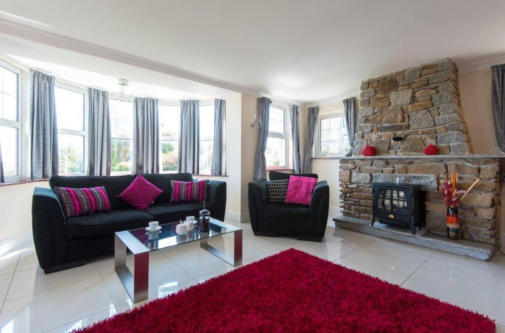 a living room with a couch and a fireplace at Rosemorran Holiday Apartments in St Ives