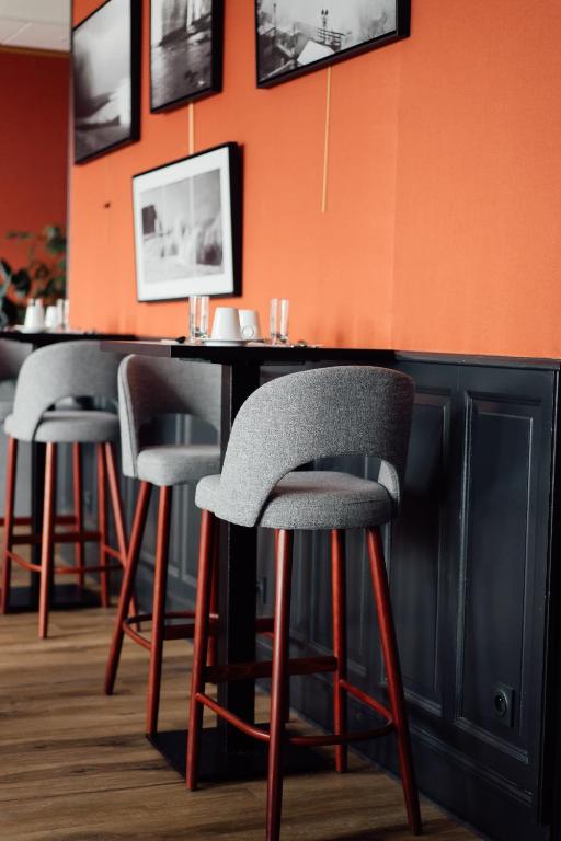 a bar with four stools in a restaurant at Dormy House in Étretat