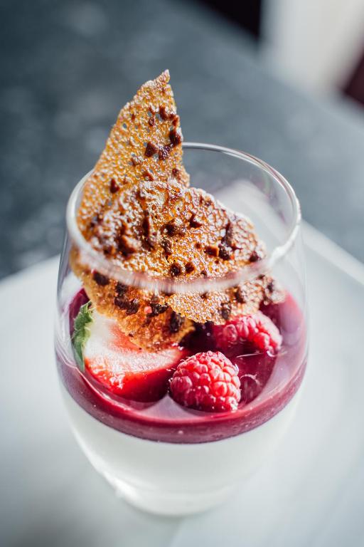 a glass dish with a piece of cake and fruit at Dormy House in Étretat