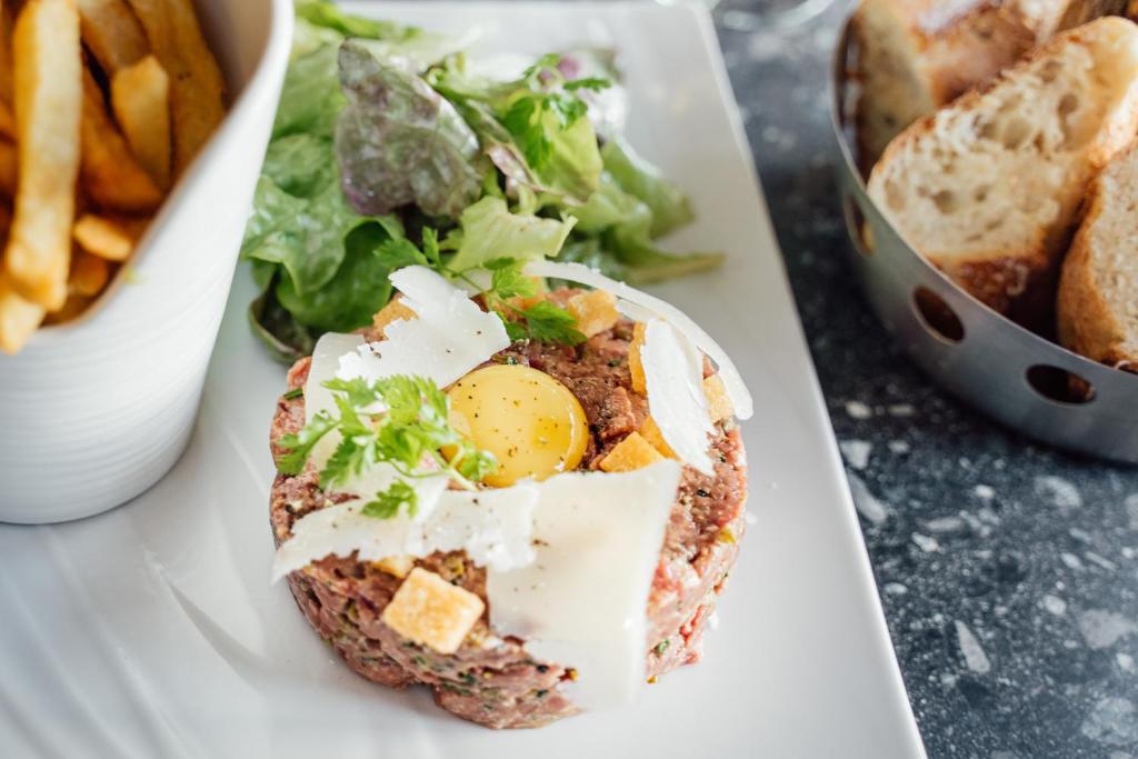 a plate with an egg and a salad and french fries at Dormy House in Étretat