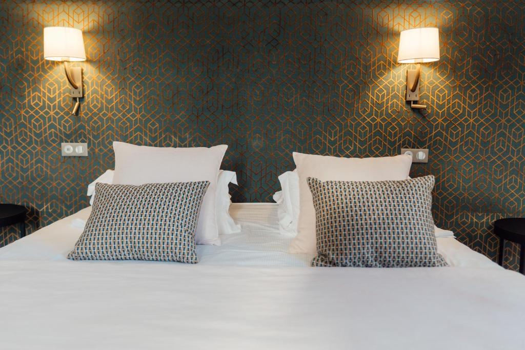 a bedroom with a white bed with two pillows at Dormy House in Étretat