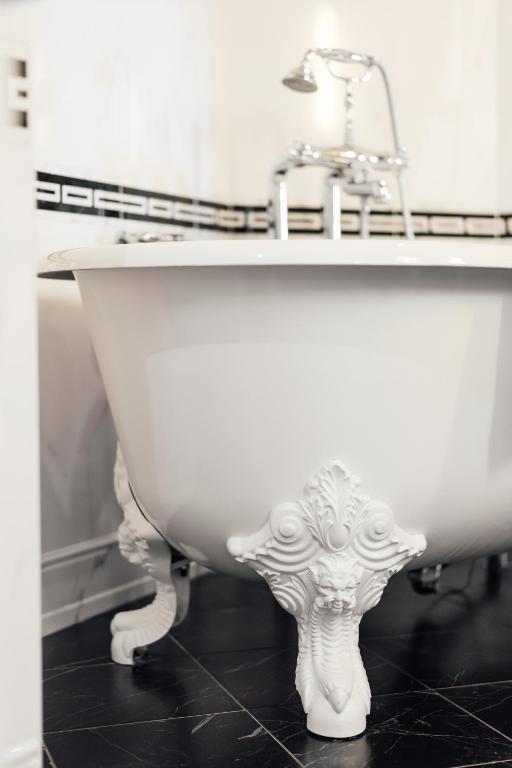 a bathroom with a sink and a white bath tub at Dormy House in Étretat