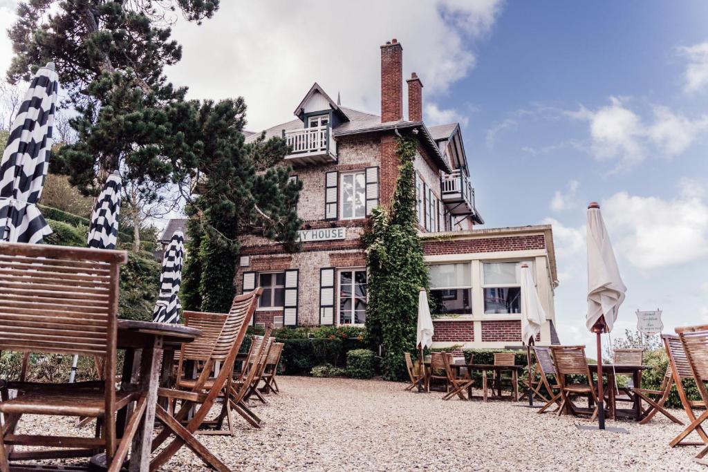 a group of chairs and tables in front of a house at Dormy House in Étretat