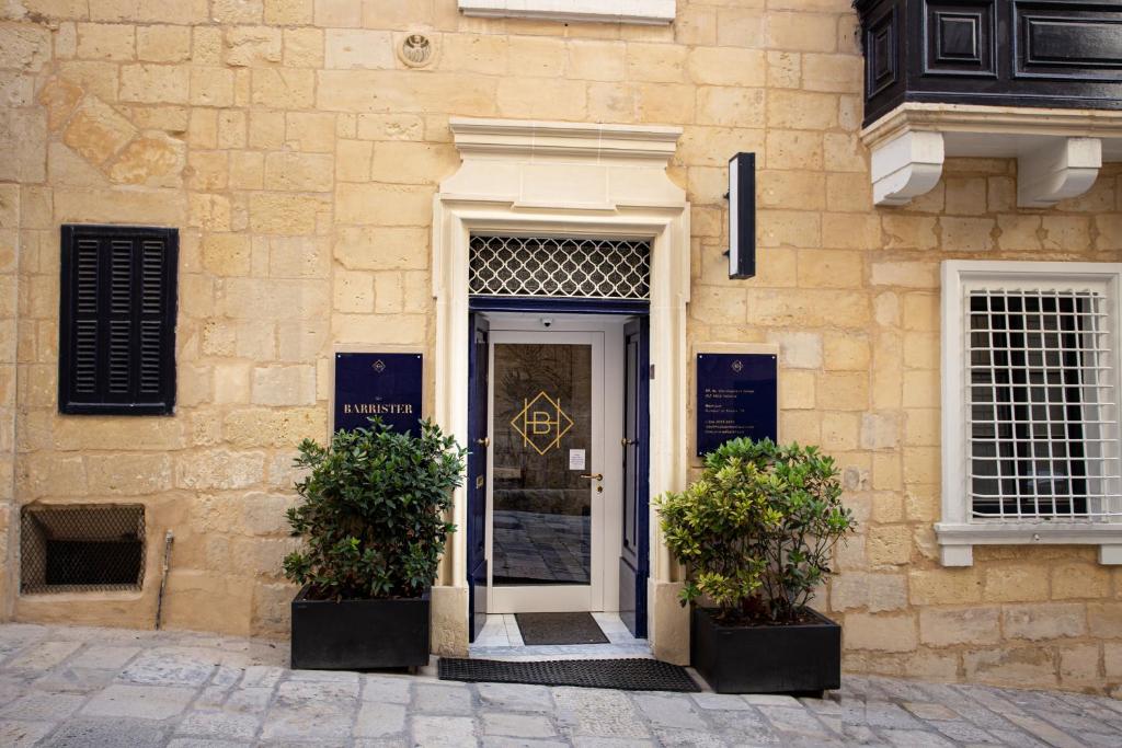 a door leading to a large window with a plant in front of it at The Barrister Hotel in Valletta