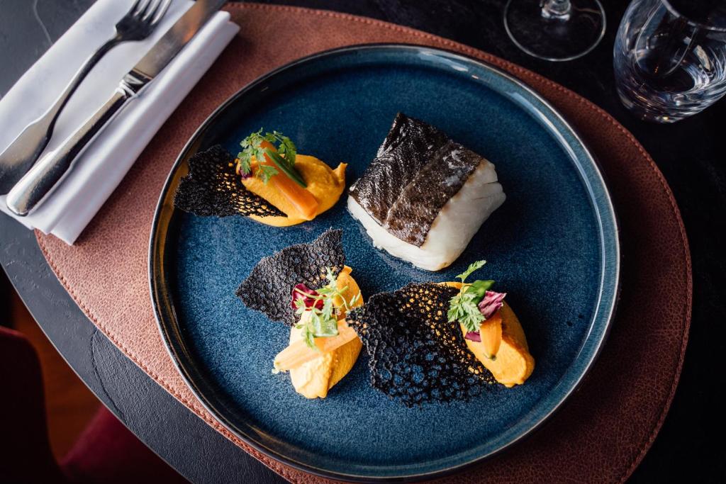 a blue plate with food on a table at Dormy House in Étretat