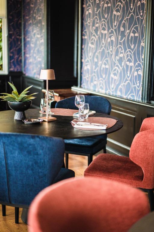 a table in a restaurant with chairs and a table with wine glasses at Dormy House in Étretat