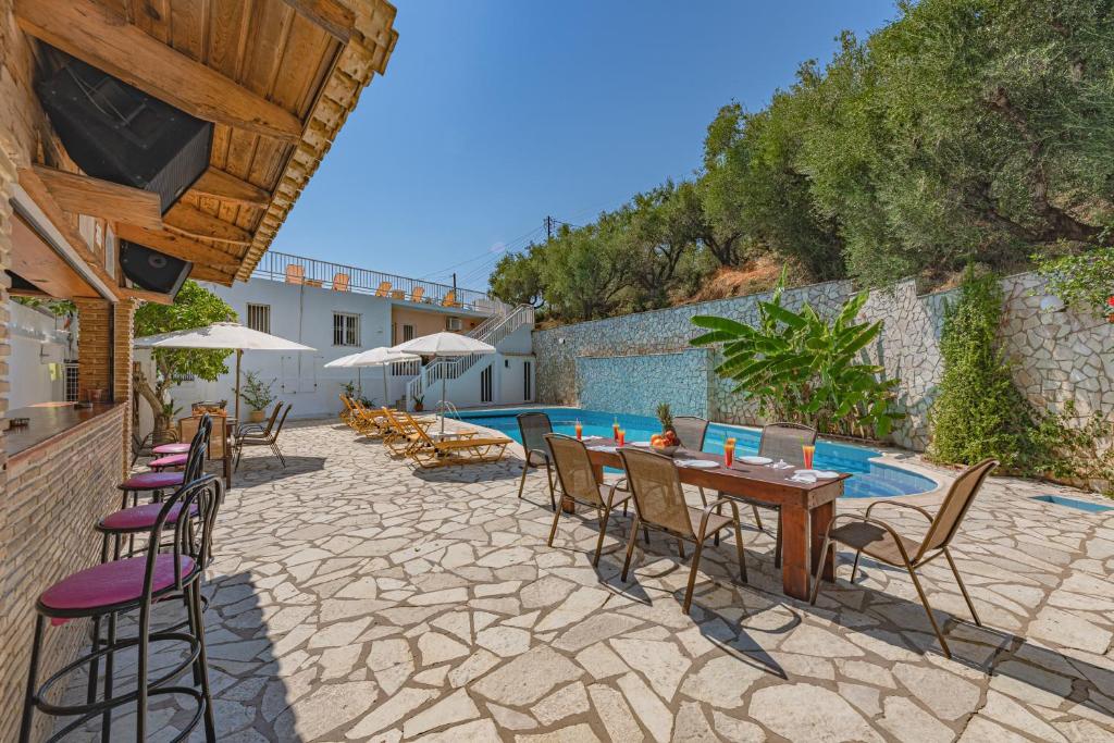 a patio with a table and chairs and a pool at Panorama in Laganas