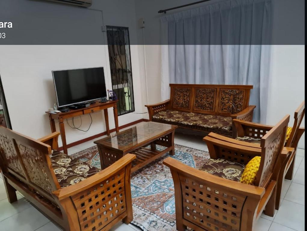 a living room with wooden furniture and a flat screen tv at Villa Suria SemiD Homestay Shah Alam in Shah Alam