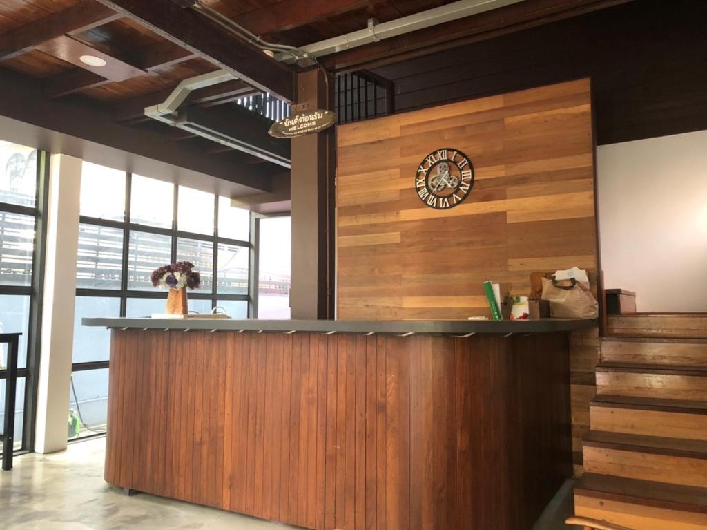 a bar in a restaurant with a clock on the wall at Bluefin Guesthouse in Bangkok