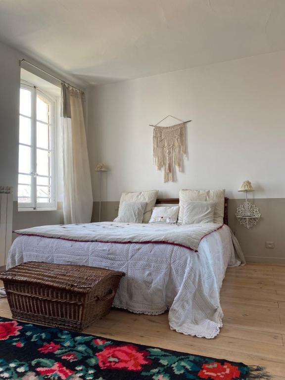 a bedroom with a large bed and a chandelier at Le logis blanc bed&breakfast in Coursan